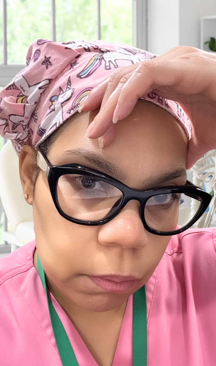 Woman wearing glasses and a pink unicorn headscarf, resting her hand on her forehead, appearing tired during her healing journey after gastric sleeve surgery.